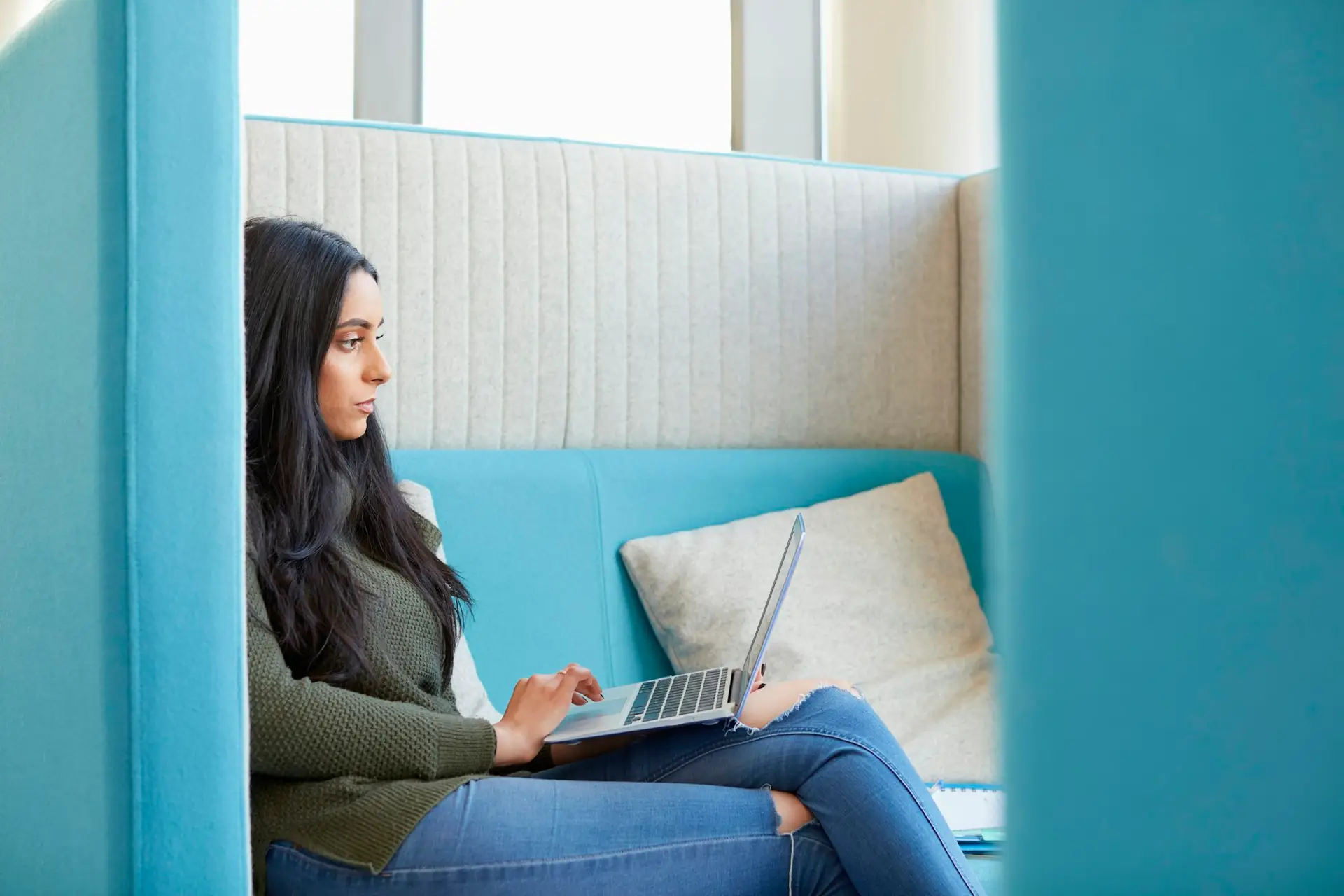 University student using laptop in modern cubicle