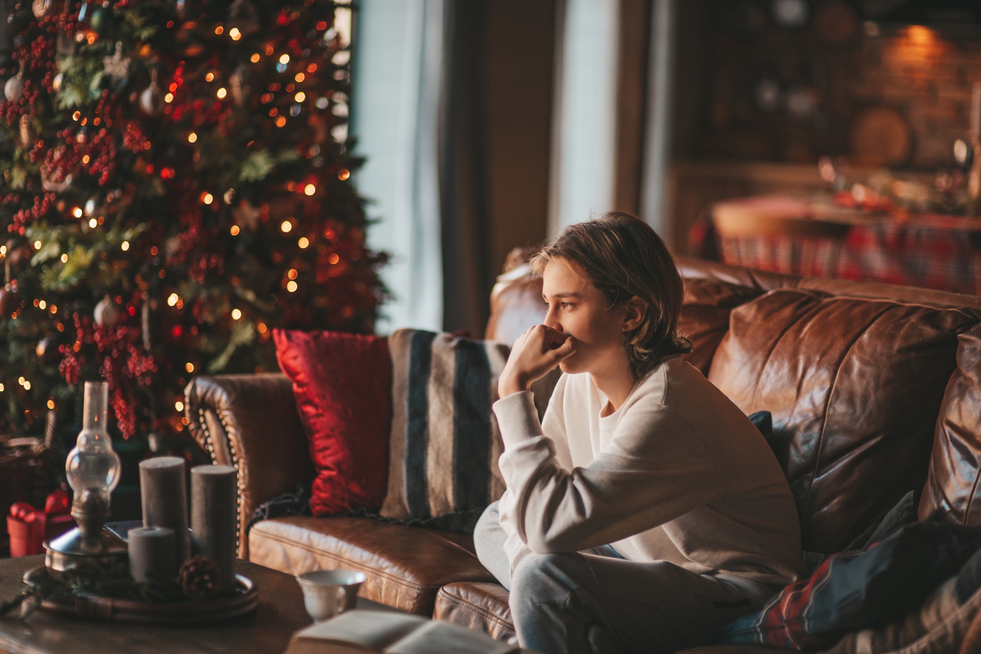 Portrait of candid authentic dreamer boy teenager in sadness depressing emotion at home Xmas