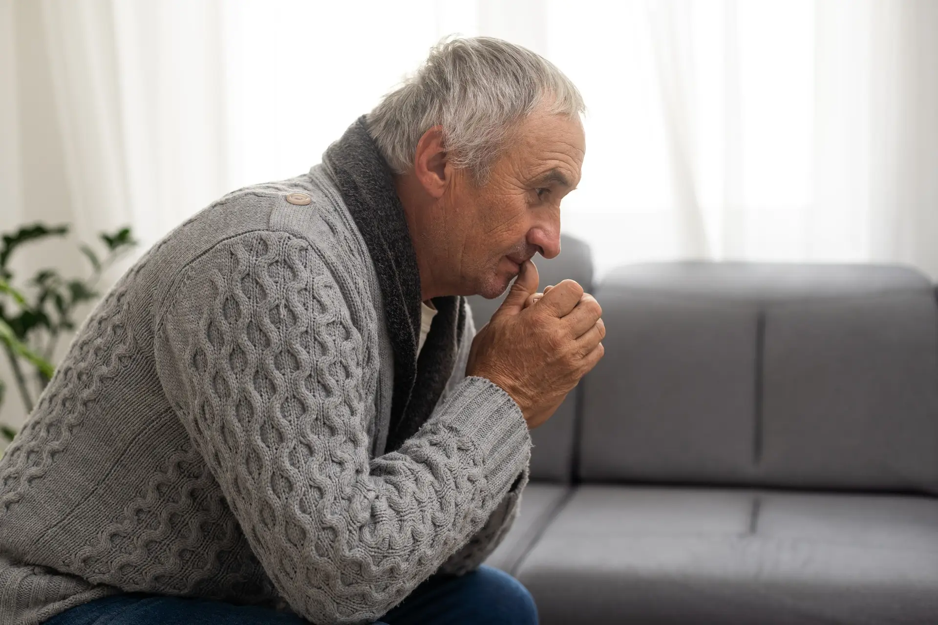 Elderly man grieves at home. Single people. Man upset headache